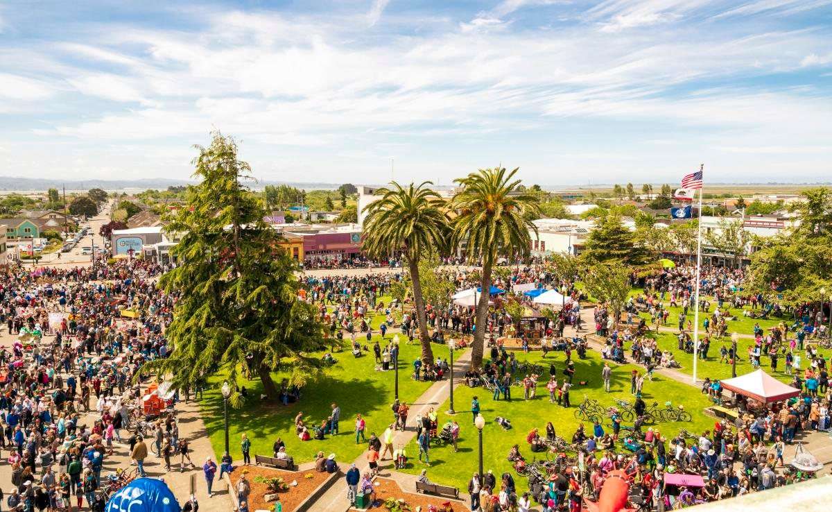Aerial view of the Arcata Plaza crowded with people and colorful vendor tents during the Friday Night Market