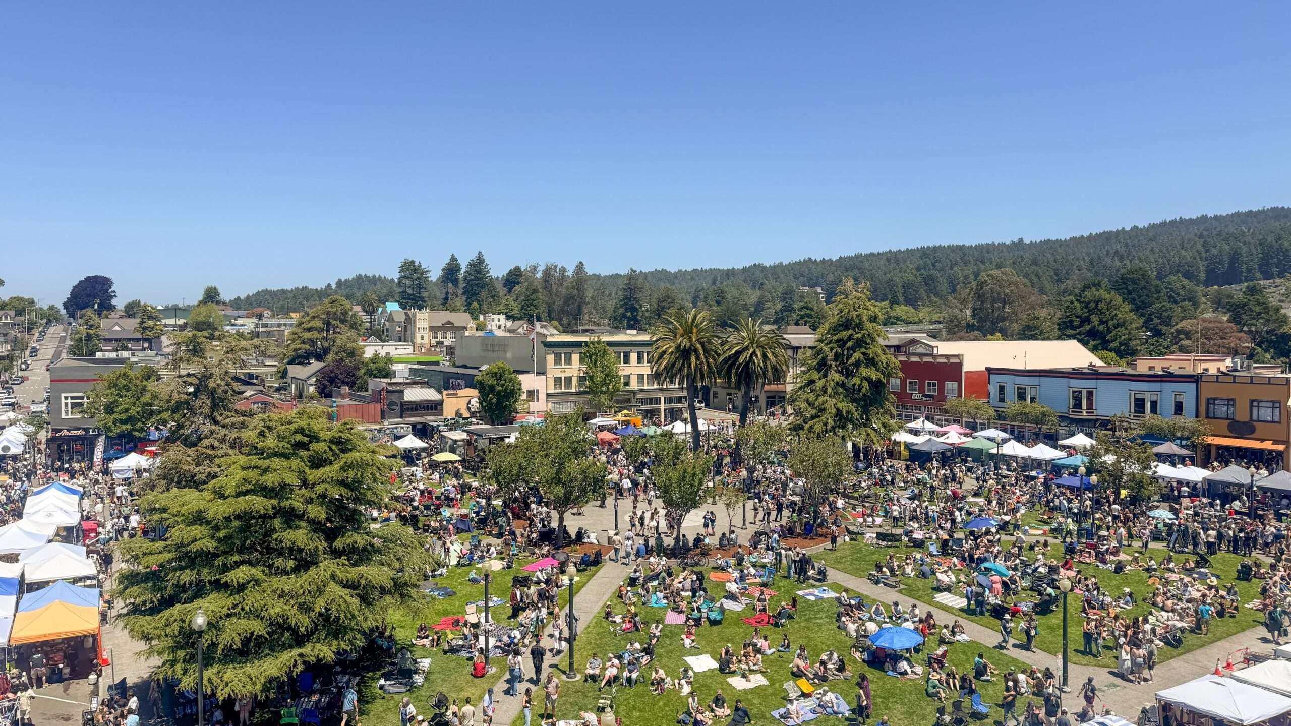 Aerial view of the Arcata Plaza packed with people and vendor tents during a summer festival