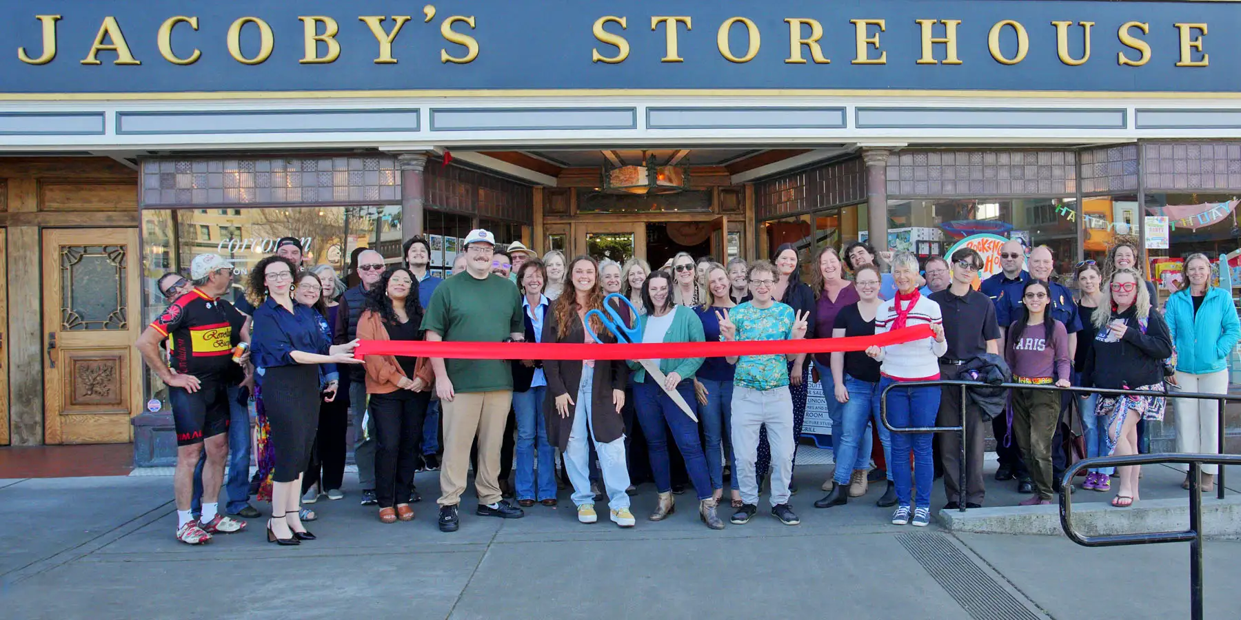 Chamber members, city staff, and neighbors cut a red ribbon outside Jacoby’s Storehouse on the Arcata Plaza
