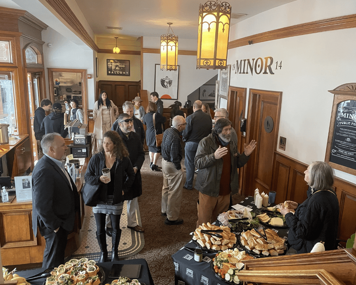 Attendees mingle around refreshment tables in a theater lobby at the 2023 State of the City